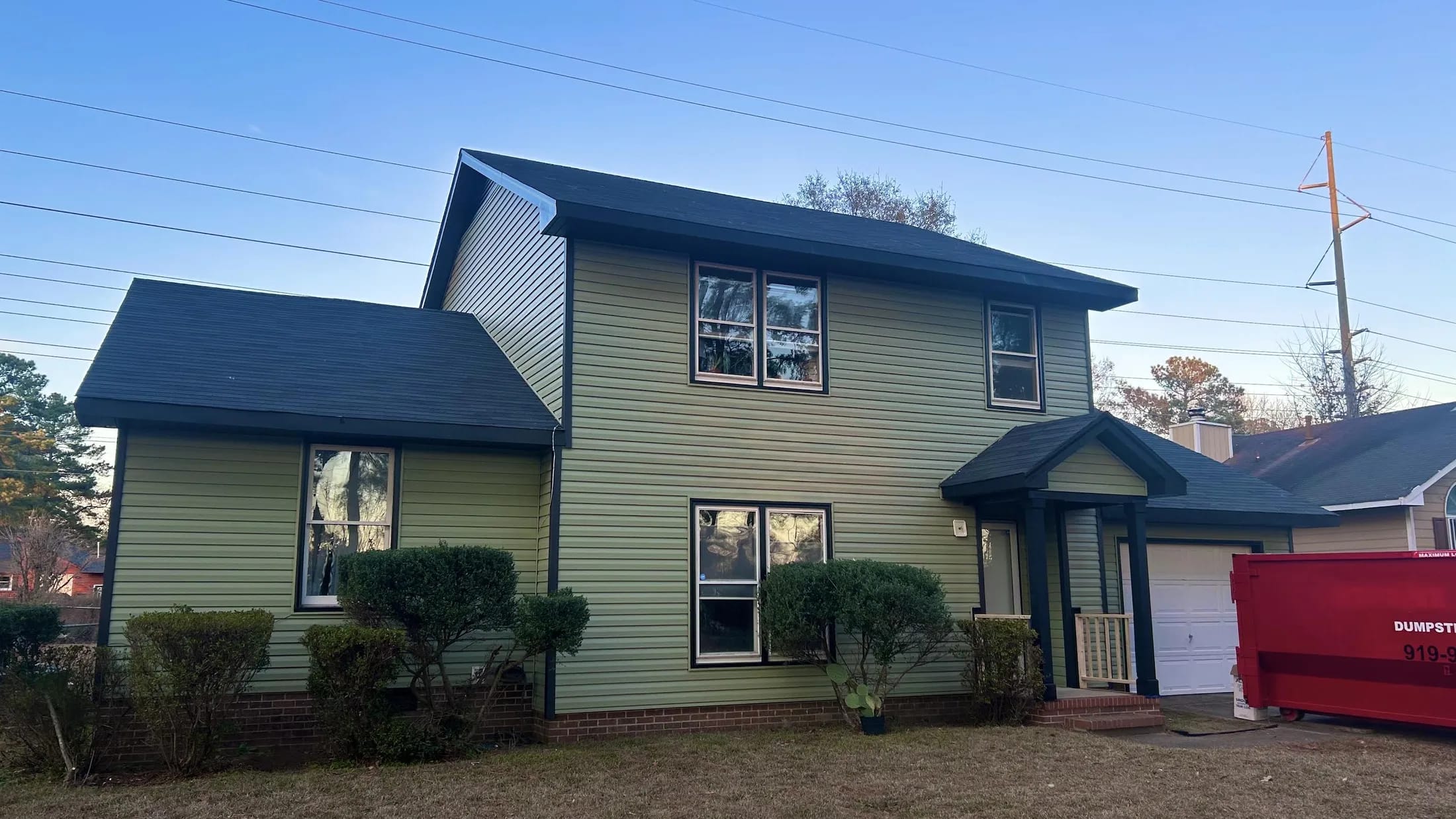 Fresh sage siding on the home after its exterior renewal.